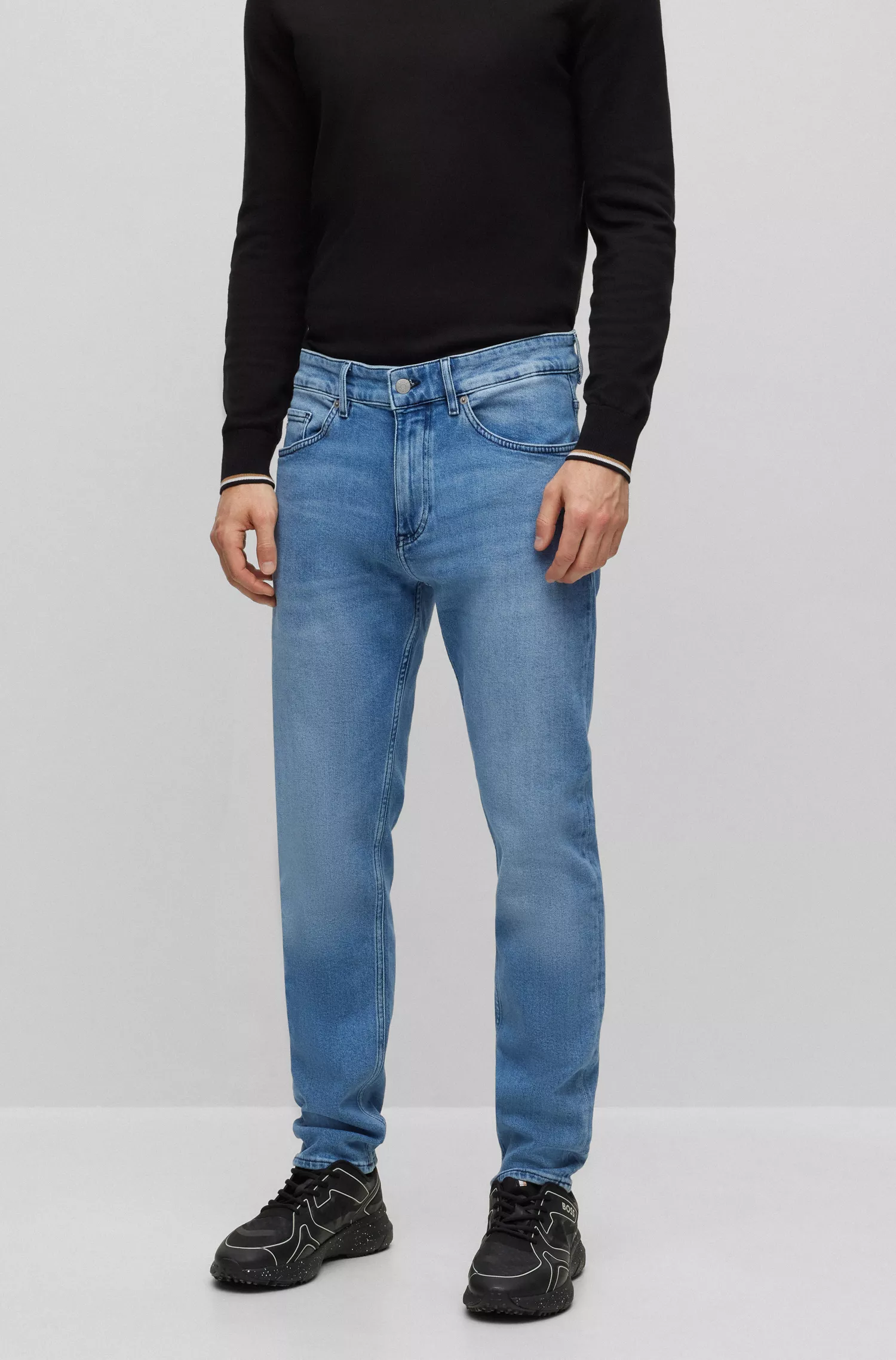 Calça jeans BOSS preta, corte afunilado, em denim azul vibrante com elasticidade confortável.
