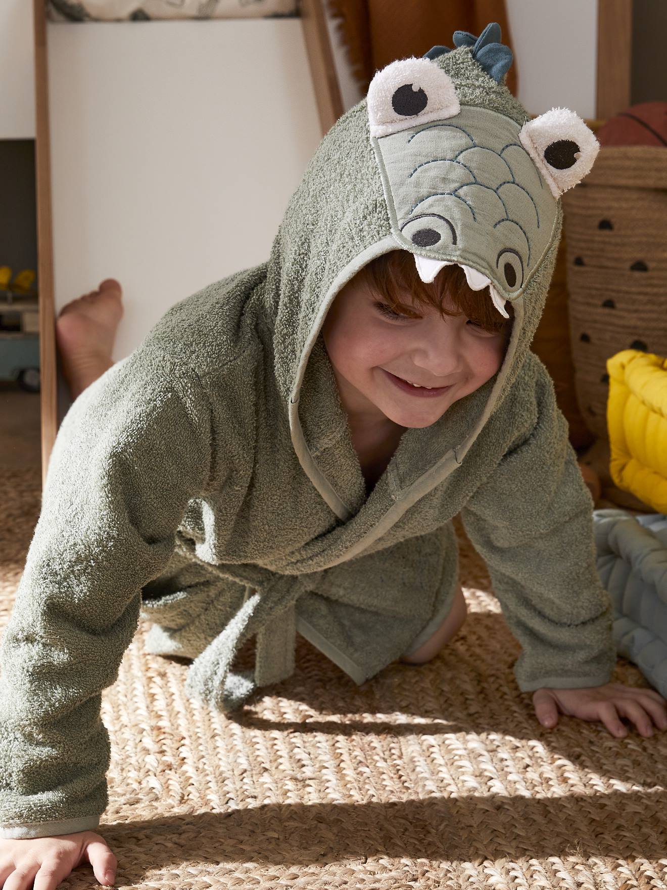 Roupão infantil, verde médio, liso, com estampa de crocodilo e detalhes.