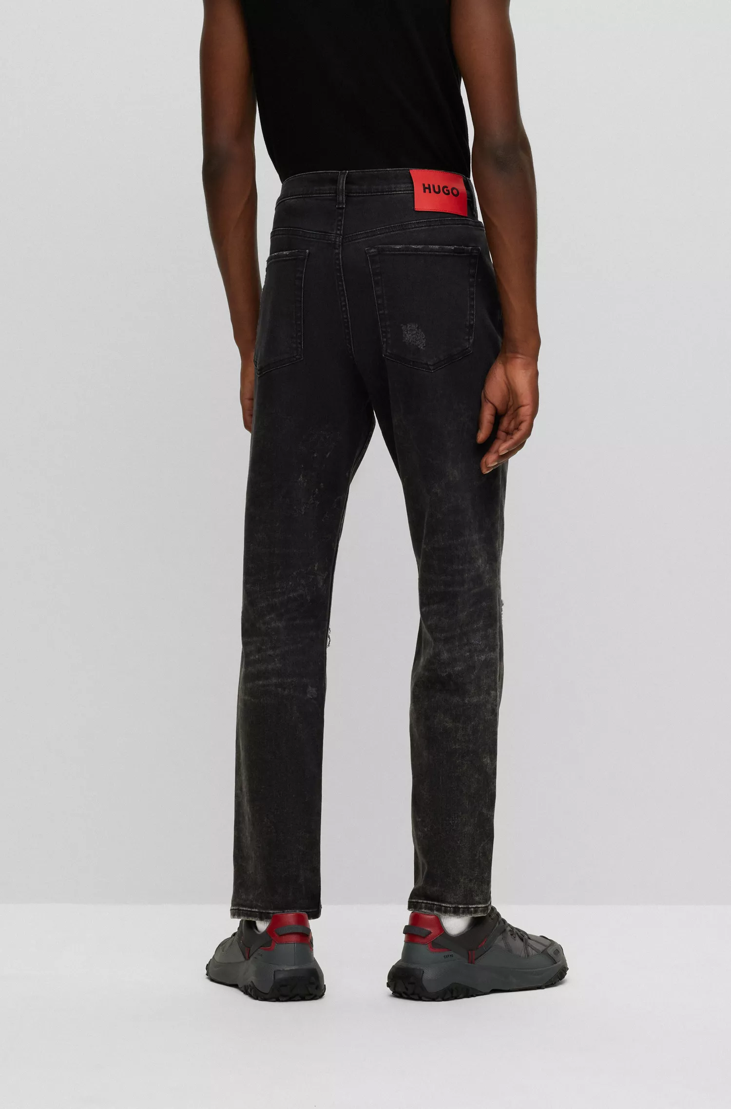 Calça jeans HUGO vermelha, corte afunilado, em denim preto com elasticidade confortável.