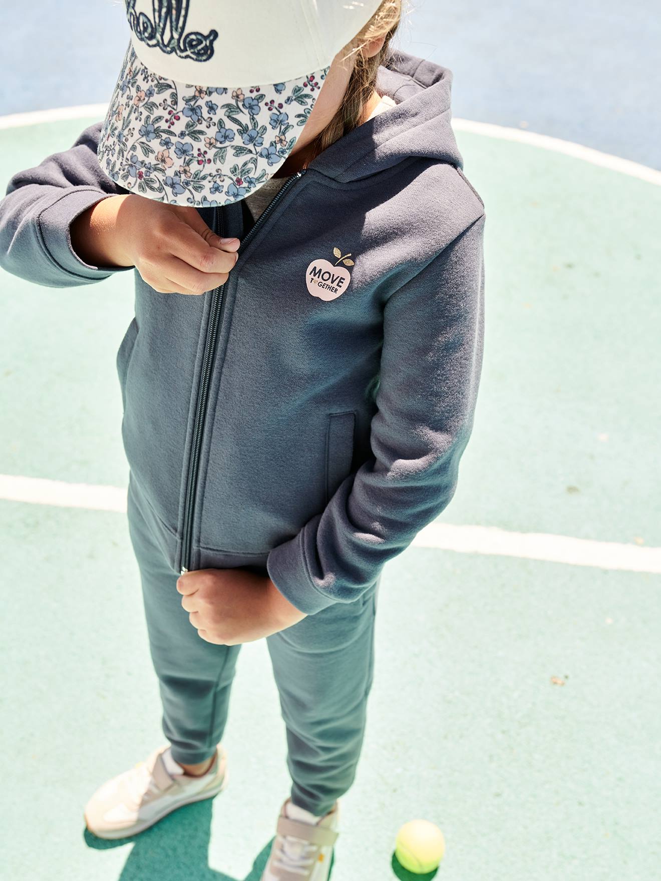 Moletom infantil feminino azul médio liso com zíper, capuz esportivo e detalhes decorativos.