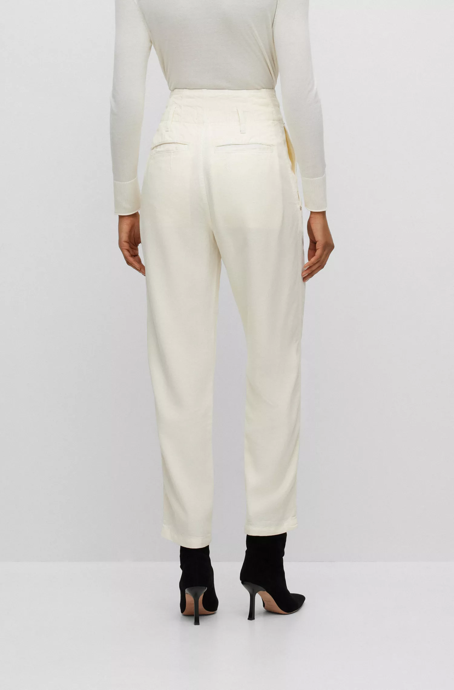 Calça BOSS preta, corte regular, com cintura plissada e pernas afuniladas.