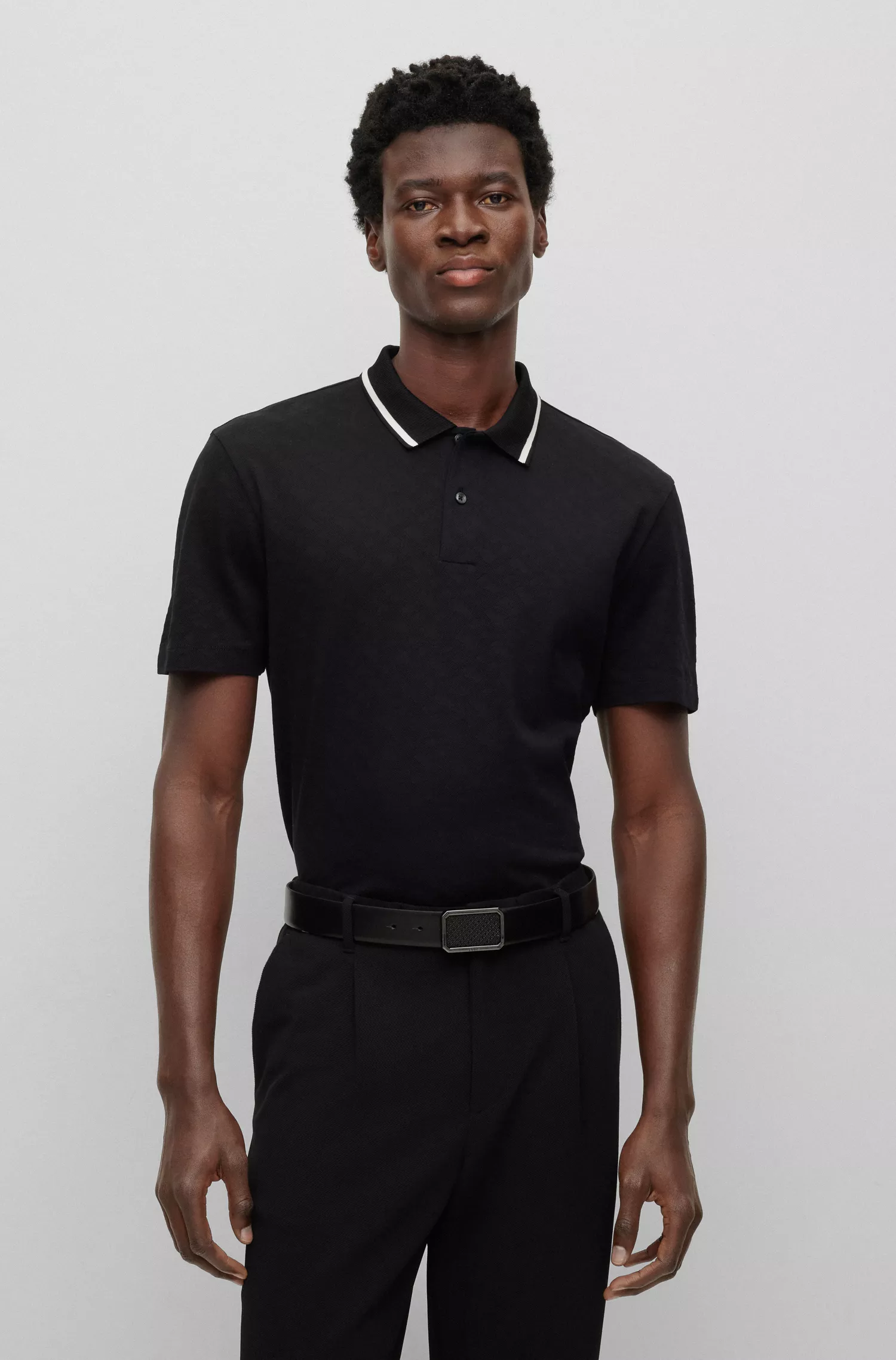 Camisa polo BOSS preta, corte regular, com jacquard de monograma.