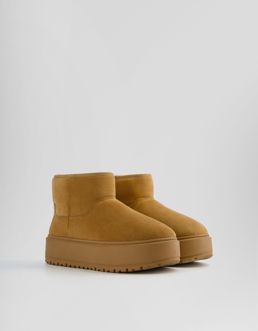 Botas de cano curto com plataforma e forro de pele sintética.