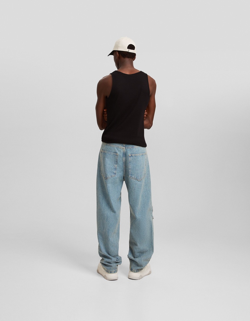 Calça jeans folgada com vários bolsos e aplicações.