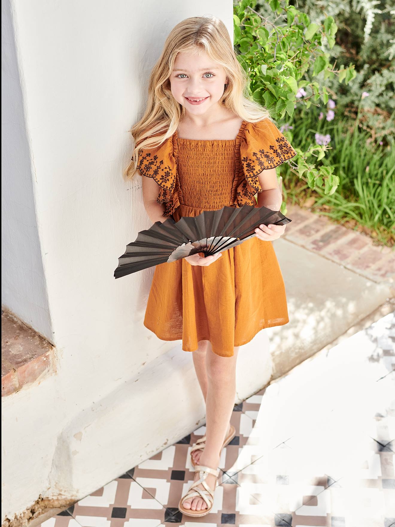 Vestido infantil em tons pastel com babados e mangas bordadas.