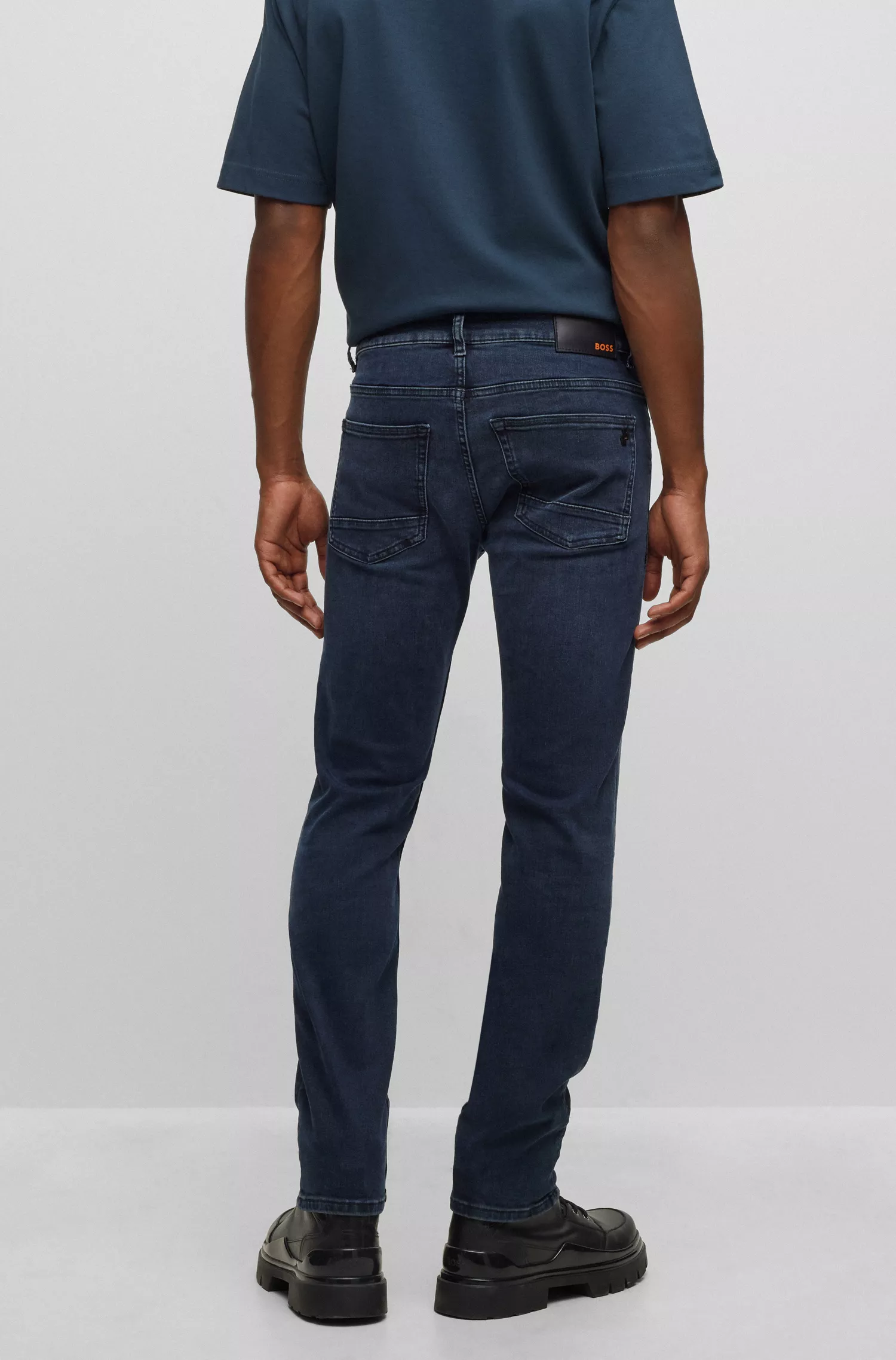 Calça jeans BOSS laranja, corte slim, em denim superelástico azul-escuro.