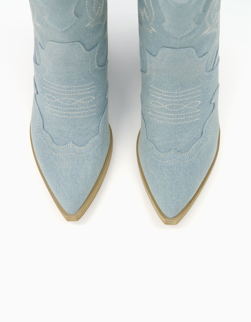 Botas de cano curto estilo cowboy em jeans com salto.