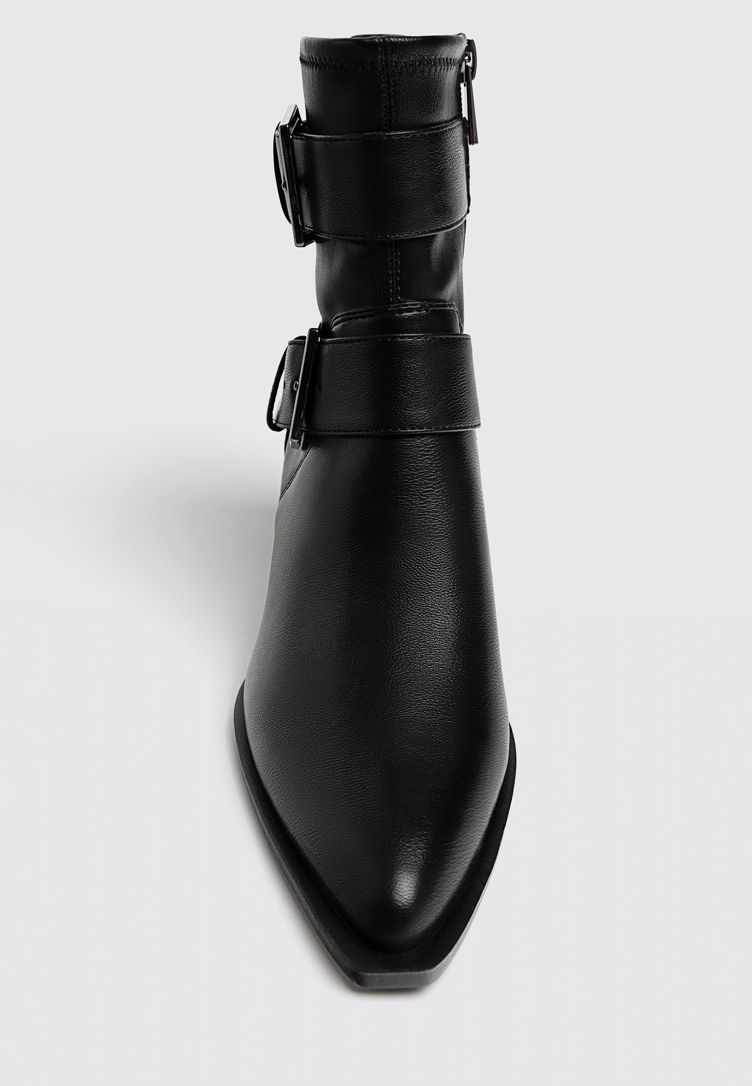 Botas pretas de cano curto com salto alto e fivelas.