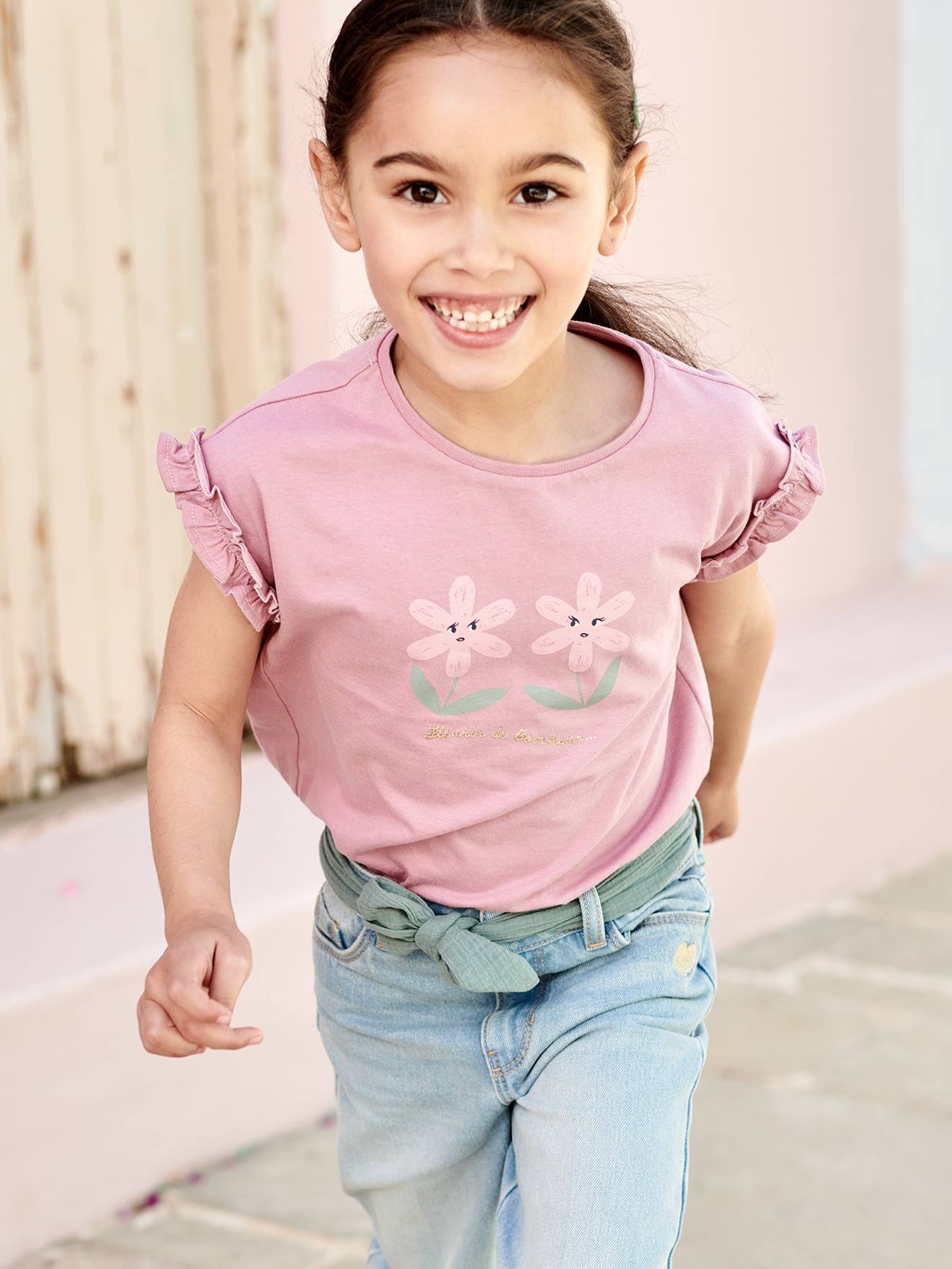 Camiseta infantil bege de manga curta com estampa iridescente e babados.
