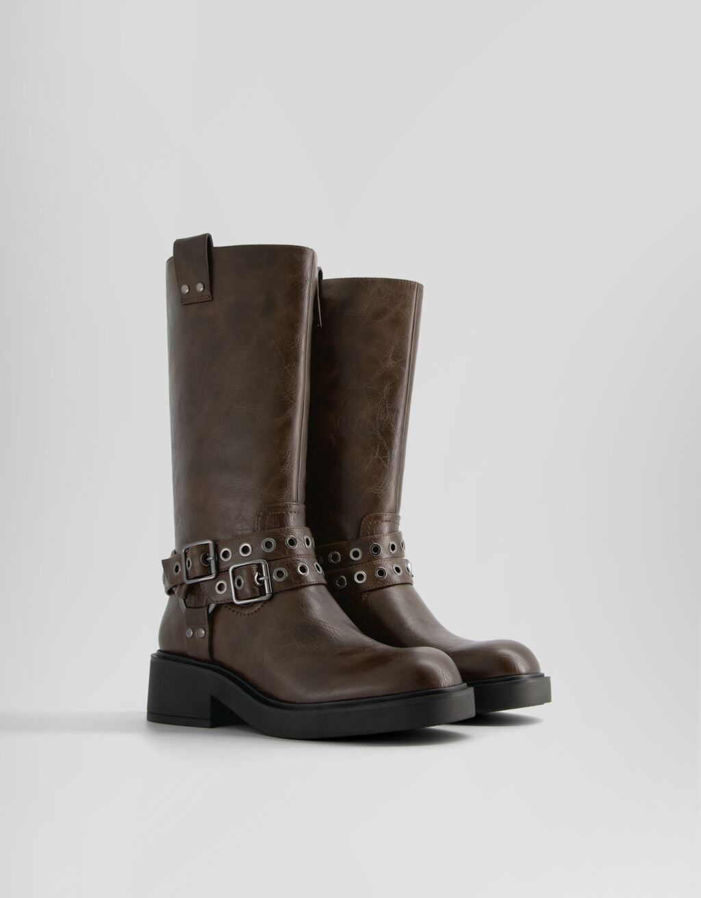 Botas de motociclista com fivelas e ilhós.