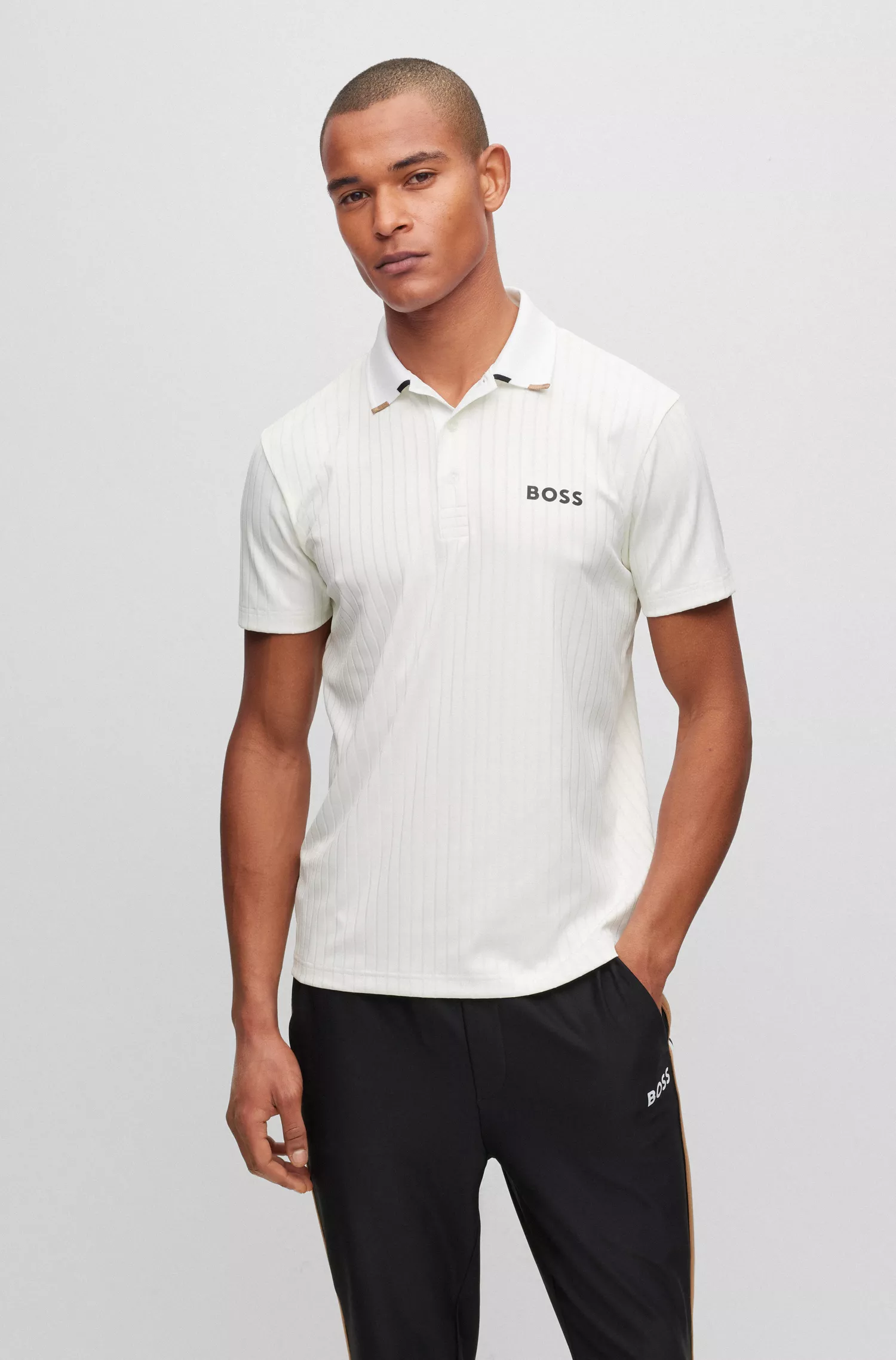 Camisa polo BOSS verde com costura drop-needle e logotipos contrastantes.
