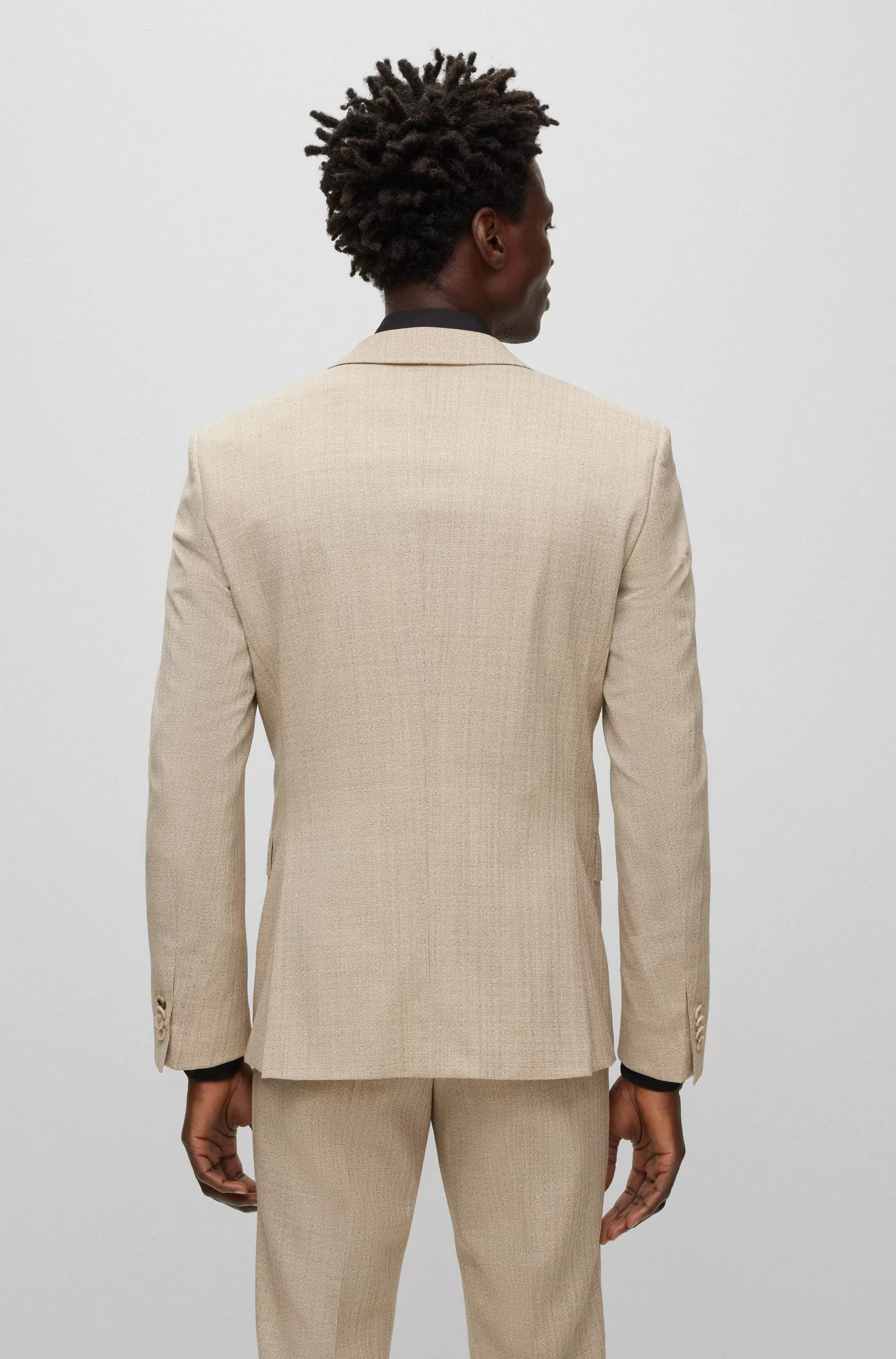 Terno BOSS preto, corte slim, em lã elástica com microestampa.