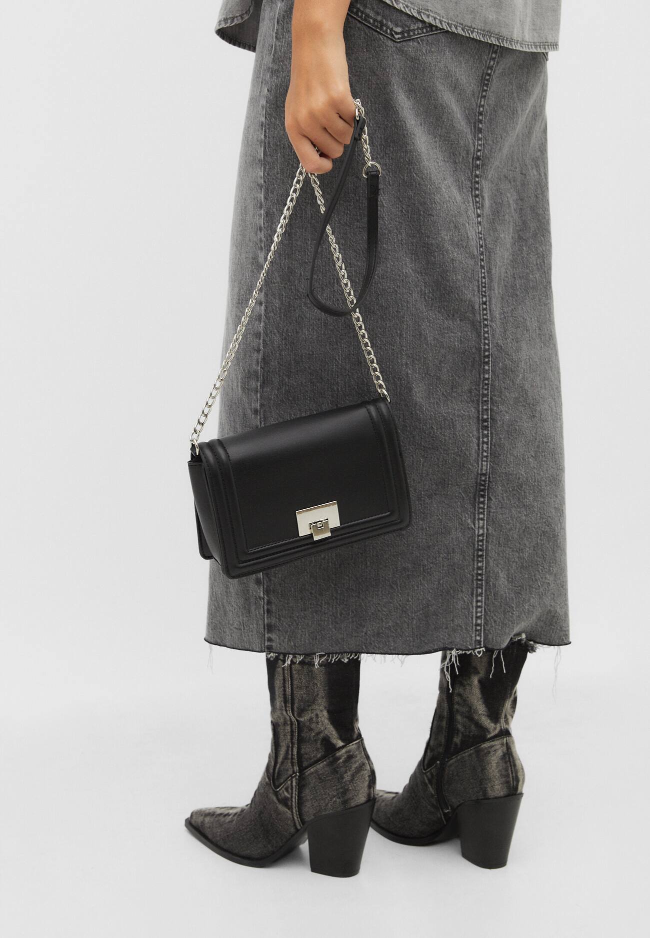 Bolsa transversal com detalhes em metal.