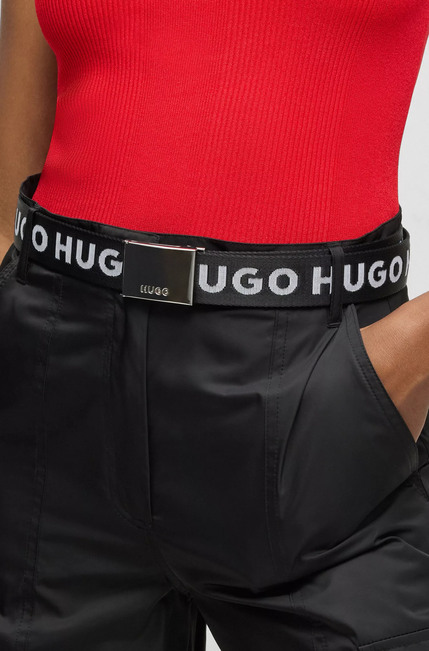 Cinto HUGO com fita vermelha com o logotipo e fivela com placa da marca.