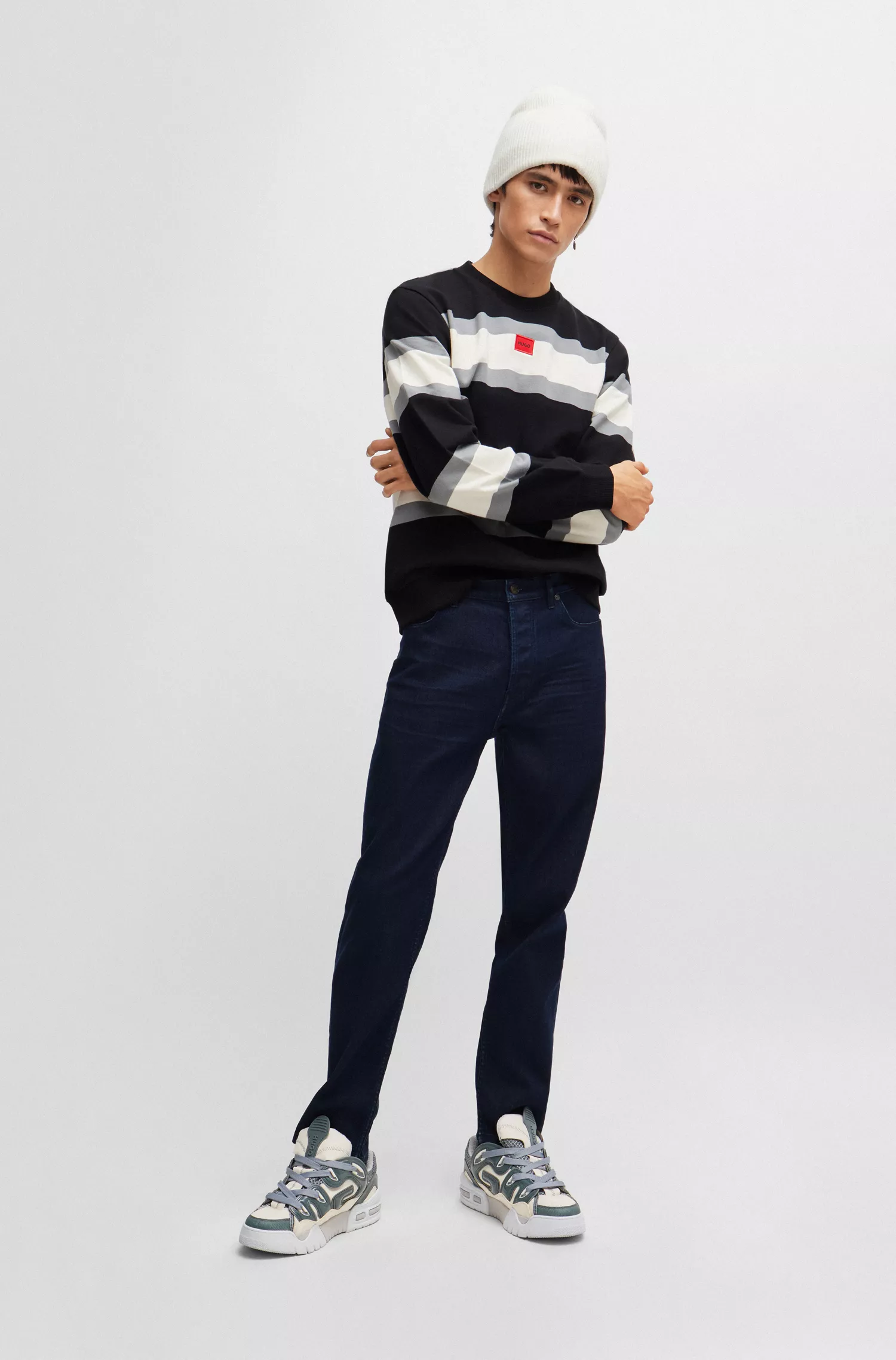 Calça jeans HUGO vermelha, corte afunilado, em denim azul-escuro com elasticidade confortável.