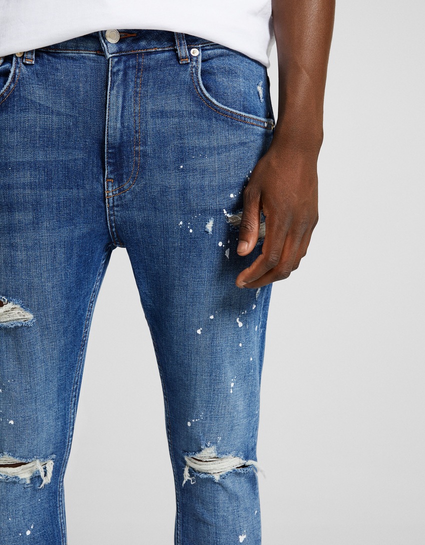 Calça jeans super skinny rasgada com respingos de tinta