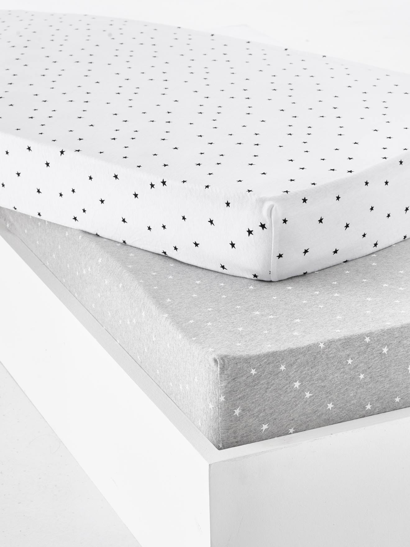 Conjunto de 2 lençóis de bebê com elástico na cintura e estampa de estrelas, na cor cinza claro.