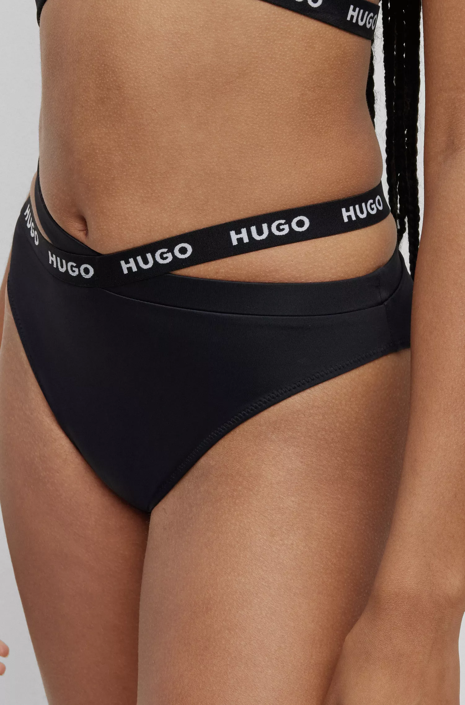 Calcinha de biquíni esportiva HUGO vermelha com fita da marca e detalhes vazados.
