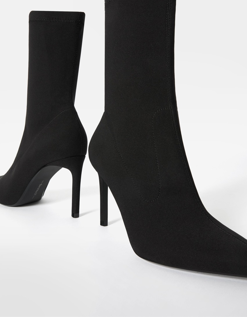 Botas de cano curto com salto alto e modelagem ajustada