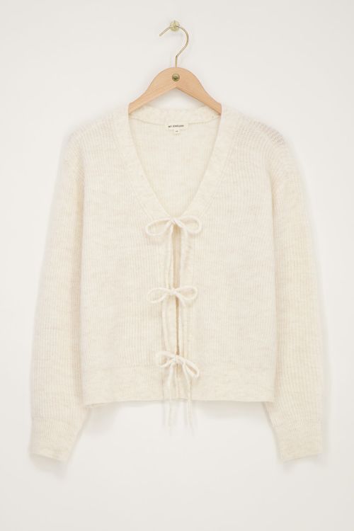 Crème vest met strikjes