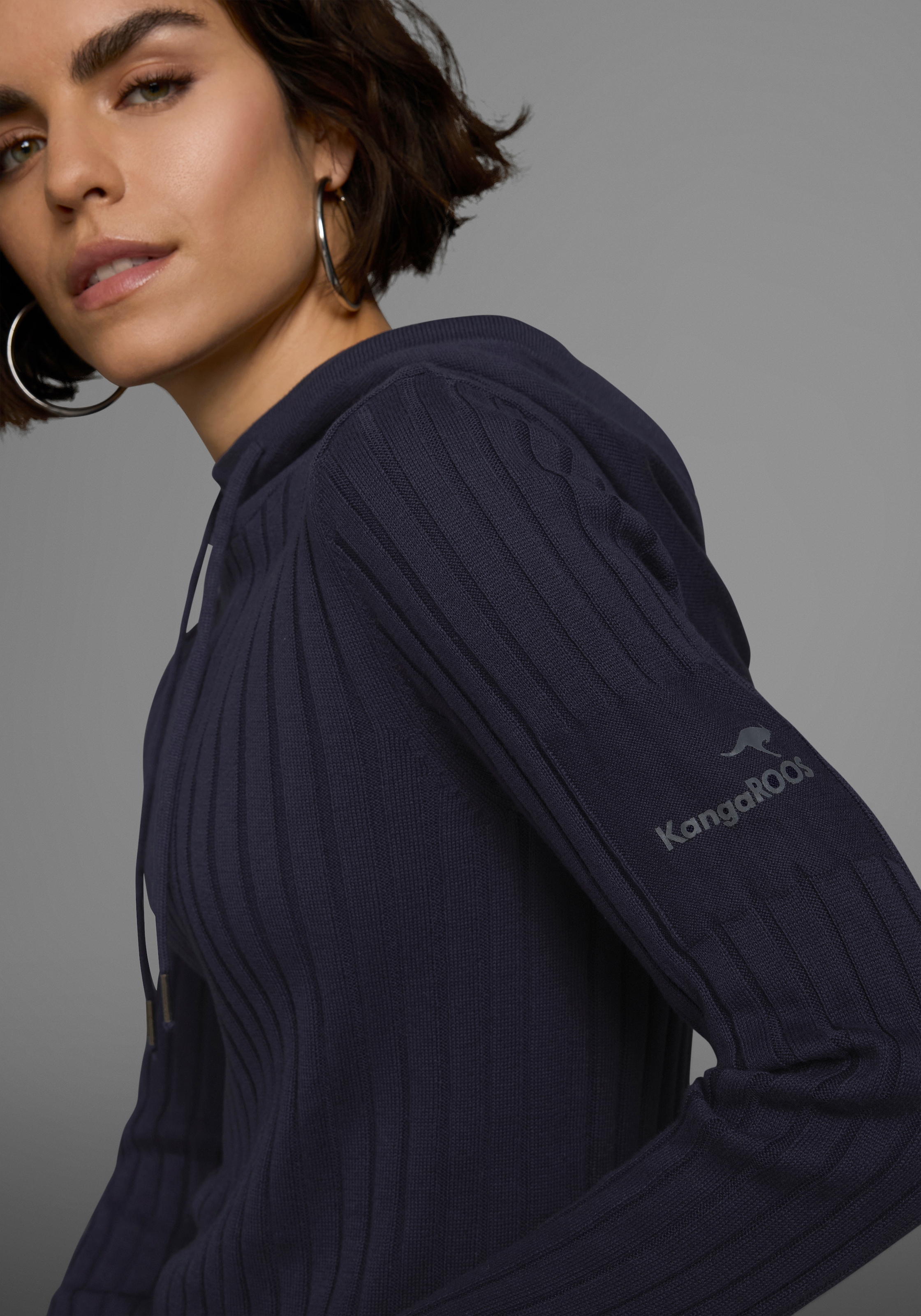 KangaROOS Strickpullover , mit kontrastfarbener Kapuzeninnenseite und Logodruck auf dem Arm