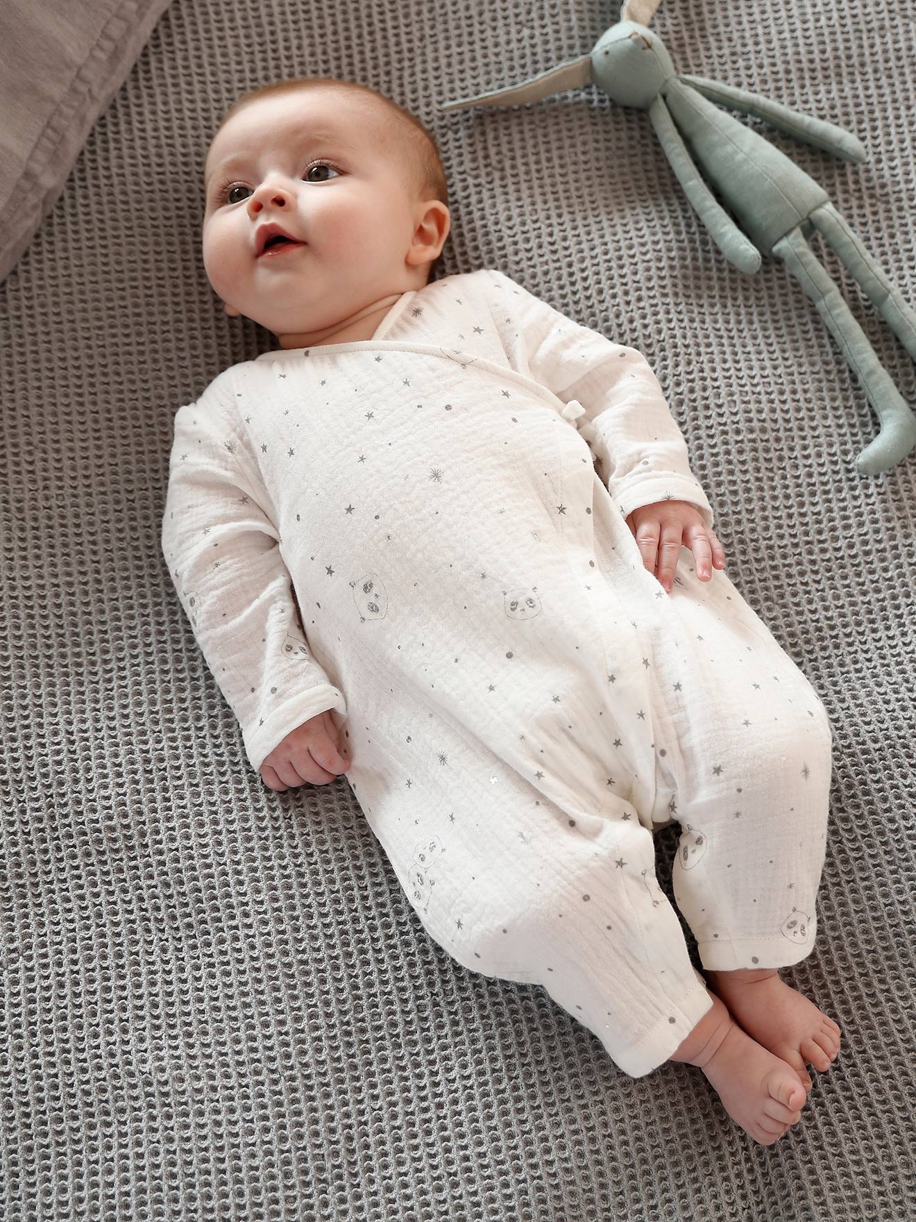 Macacão infantil em chiffon de algodão branco claro com estampa e decote cruzado.