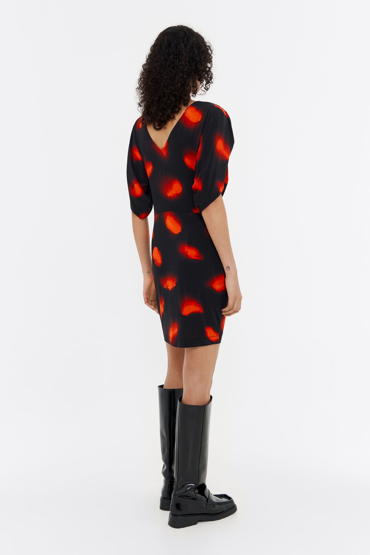 Vestido curto vermelho com ombros à mostra e penas