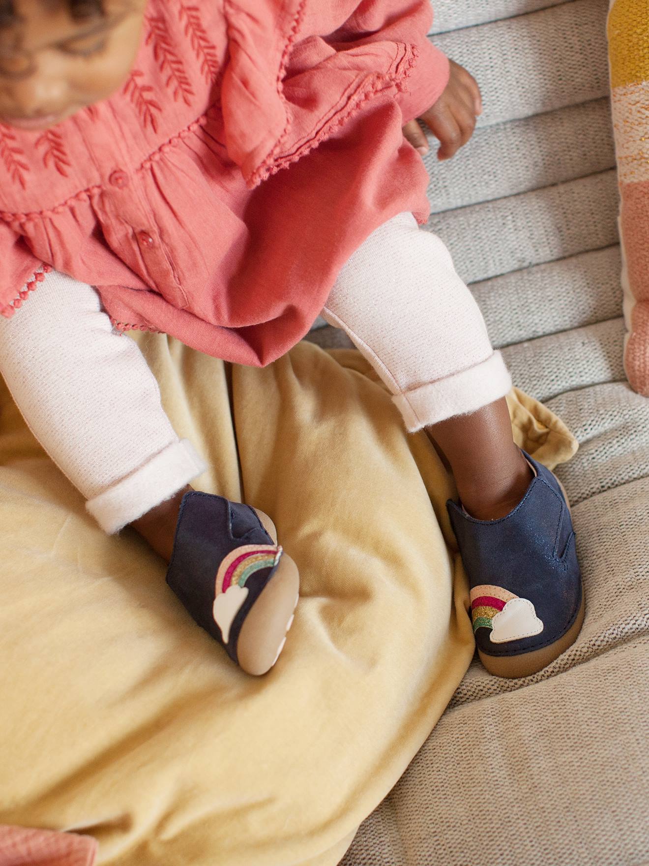 Pantufas de bebê em couro claro, lisas em azul escuro com estampas.