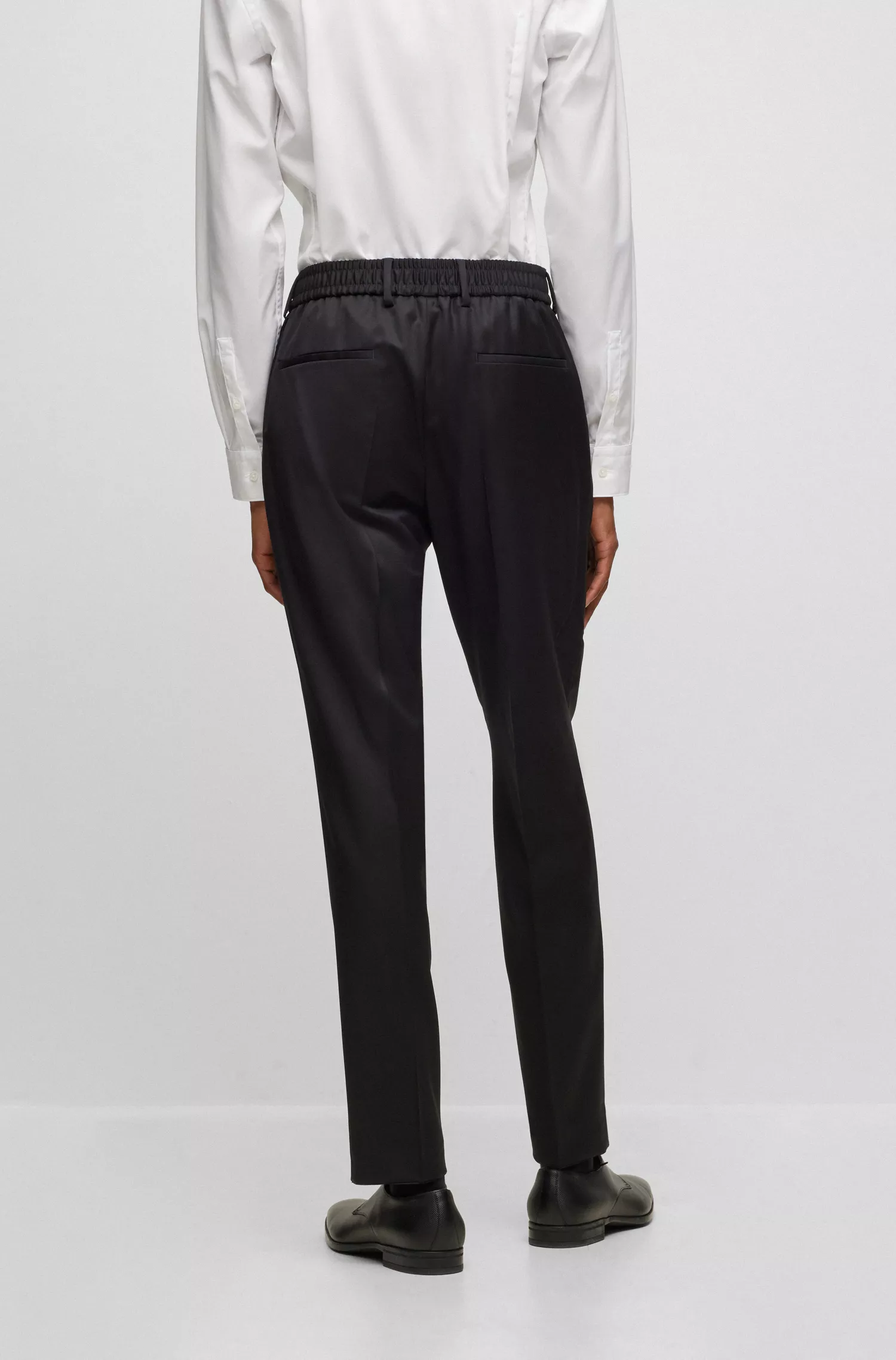 Calça BOSS preta, corte slim, em lã virgem, com cintura ajustável por cordão.