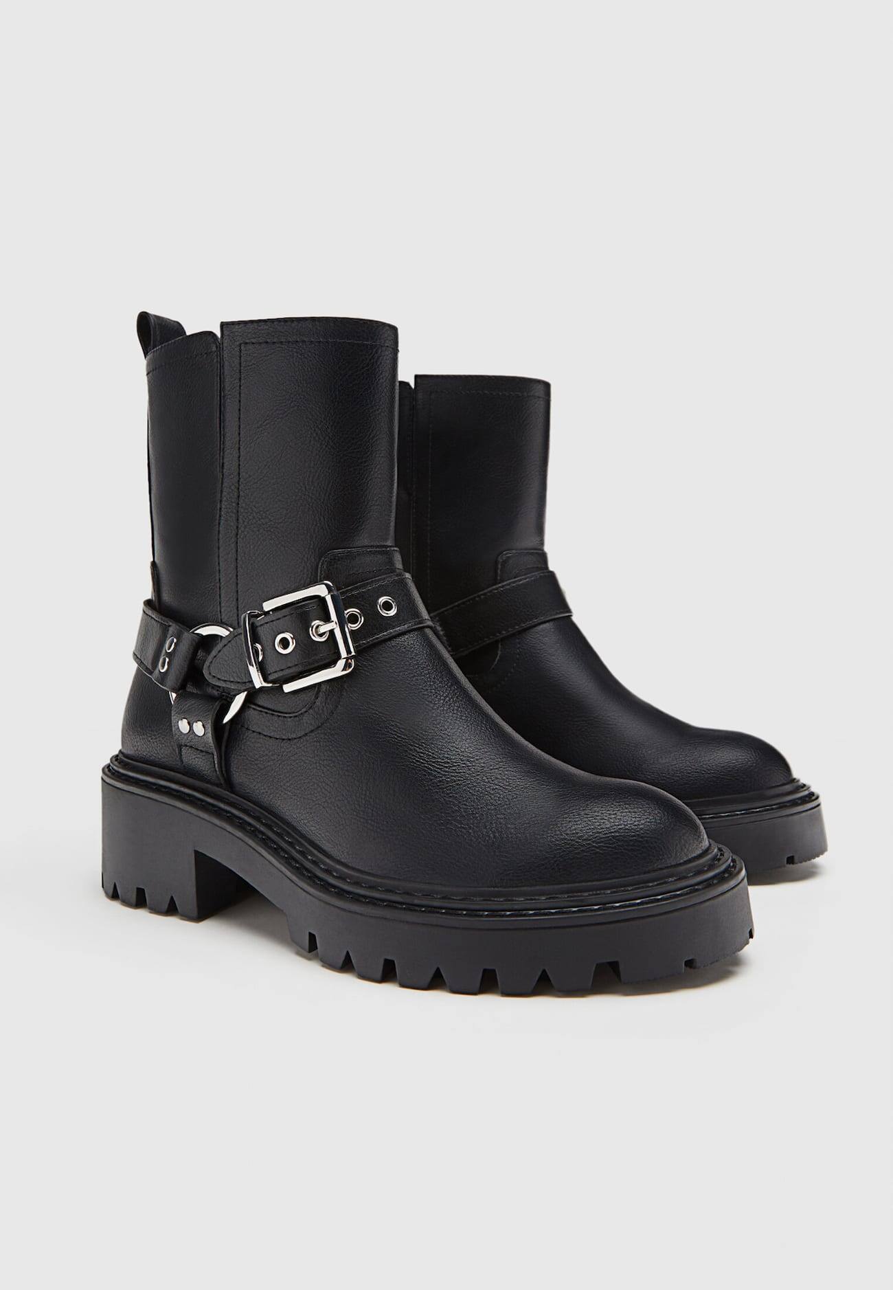Botas de cano curto estilo motociclista, sem salto, com detalhes de fivela.