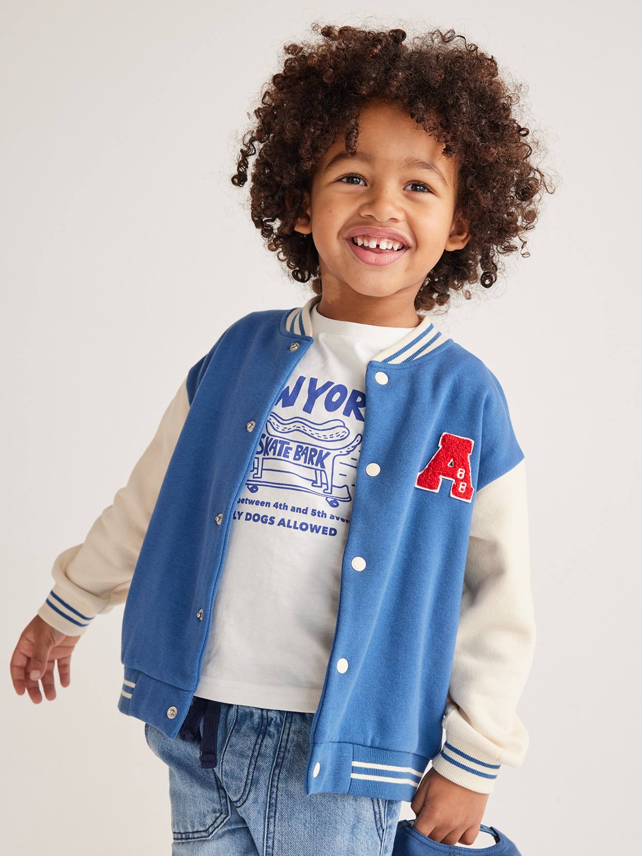 Moletom universitário azul infantil estilo teddy com botões de pressão na frente.