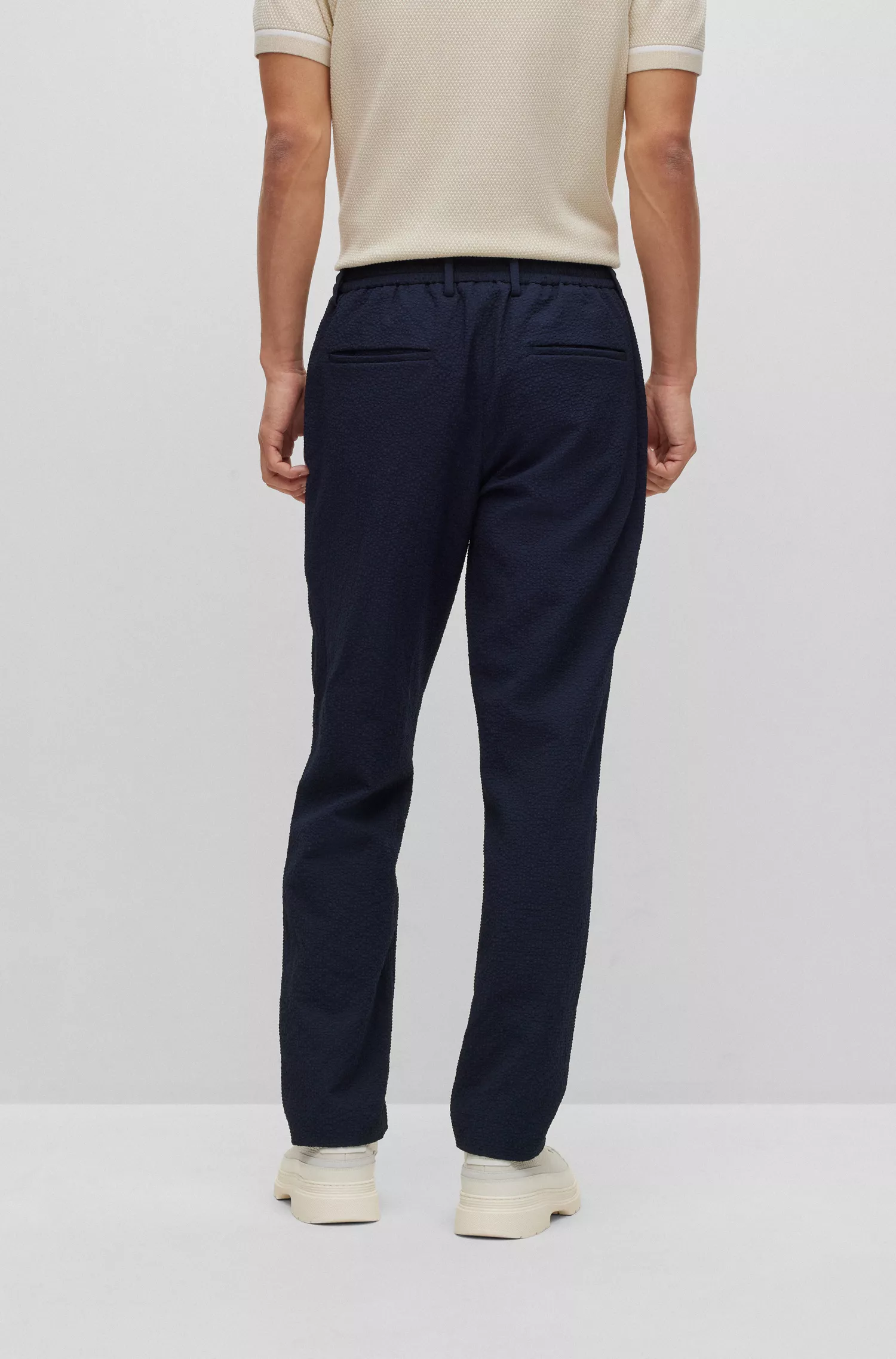 Calça BOSS preta de corte slim em tecido seersucker de alta performance com elasticidade.