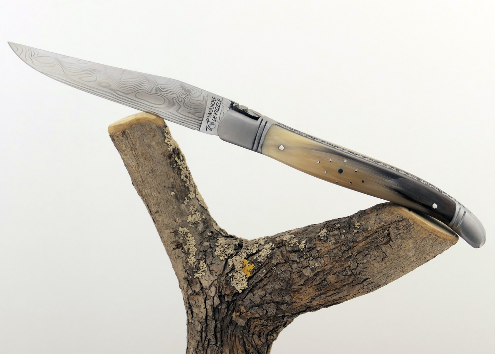 Couteau Laguiole prestige avec un manche en pointe de corne blonde et mitres en acier inoxydable et lame Damas
