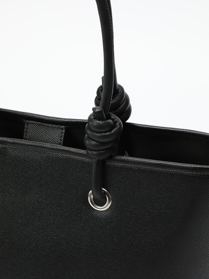 Bolsa preta em couro sintético com nó.