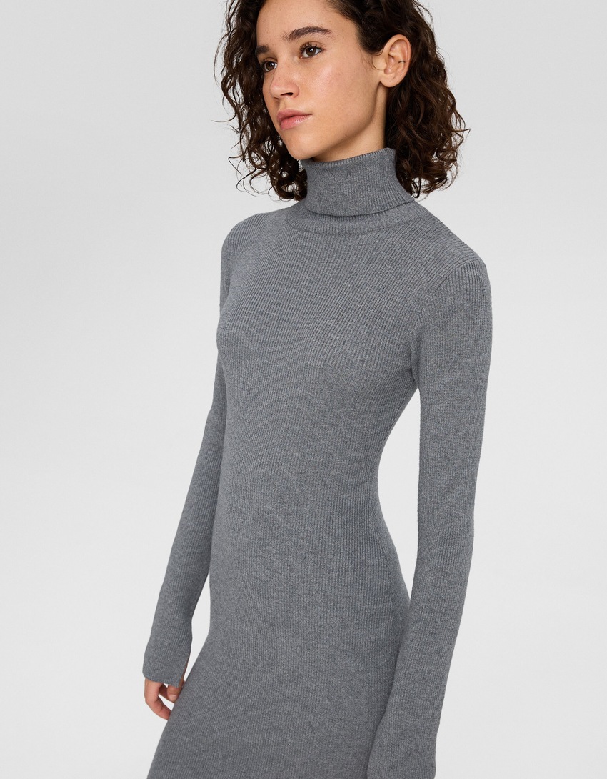 Vestido curto de malha com gola alta e mangas compridas.