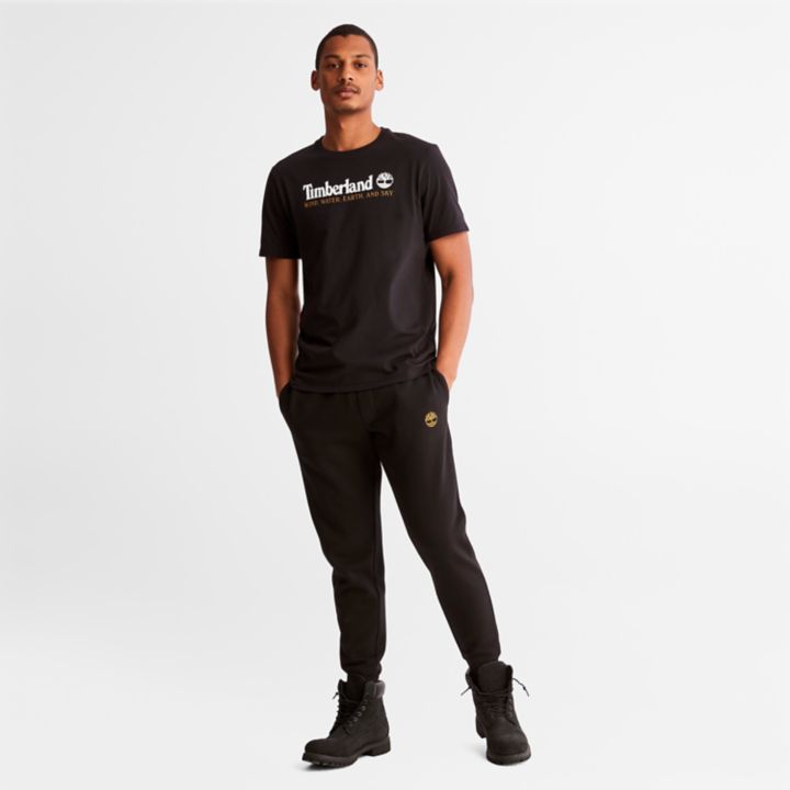 Camiseta masculina preta com estampa de vento, água, terra e céu.