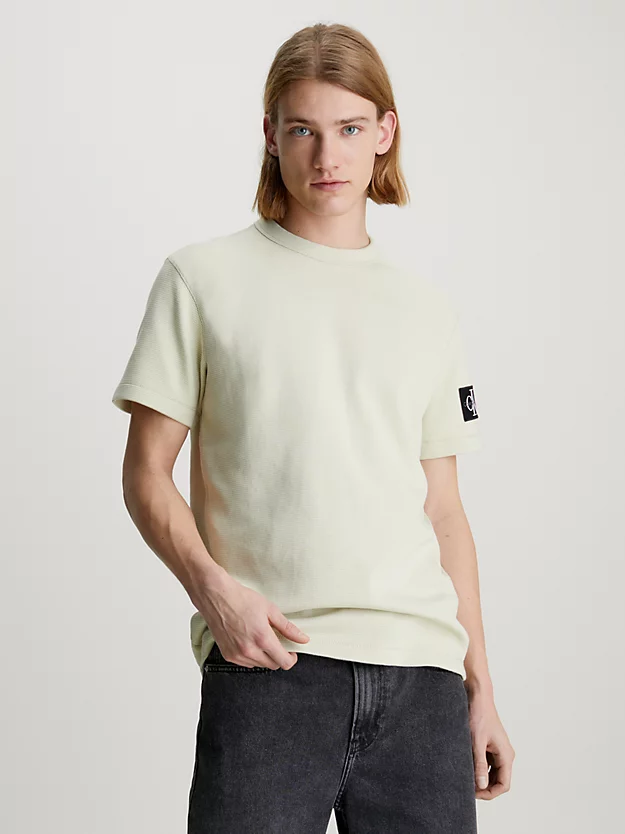 Camiseta de algodão com textura alveolar e modelagem slim, com brasão.