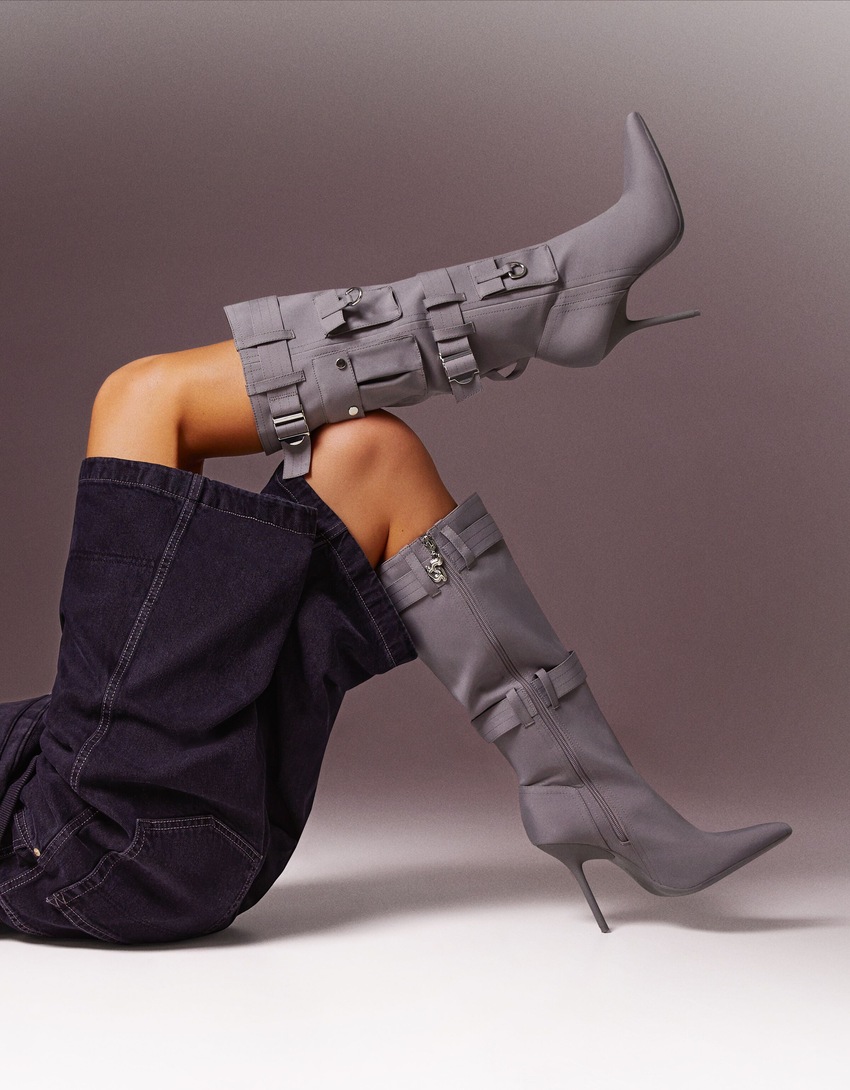 Botas de salto agulha com bolsos com detalhes em metal.