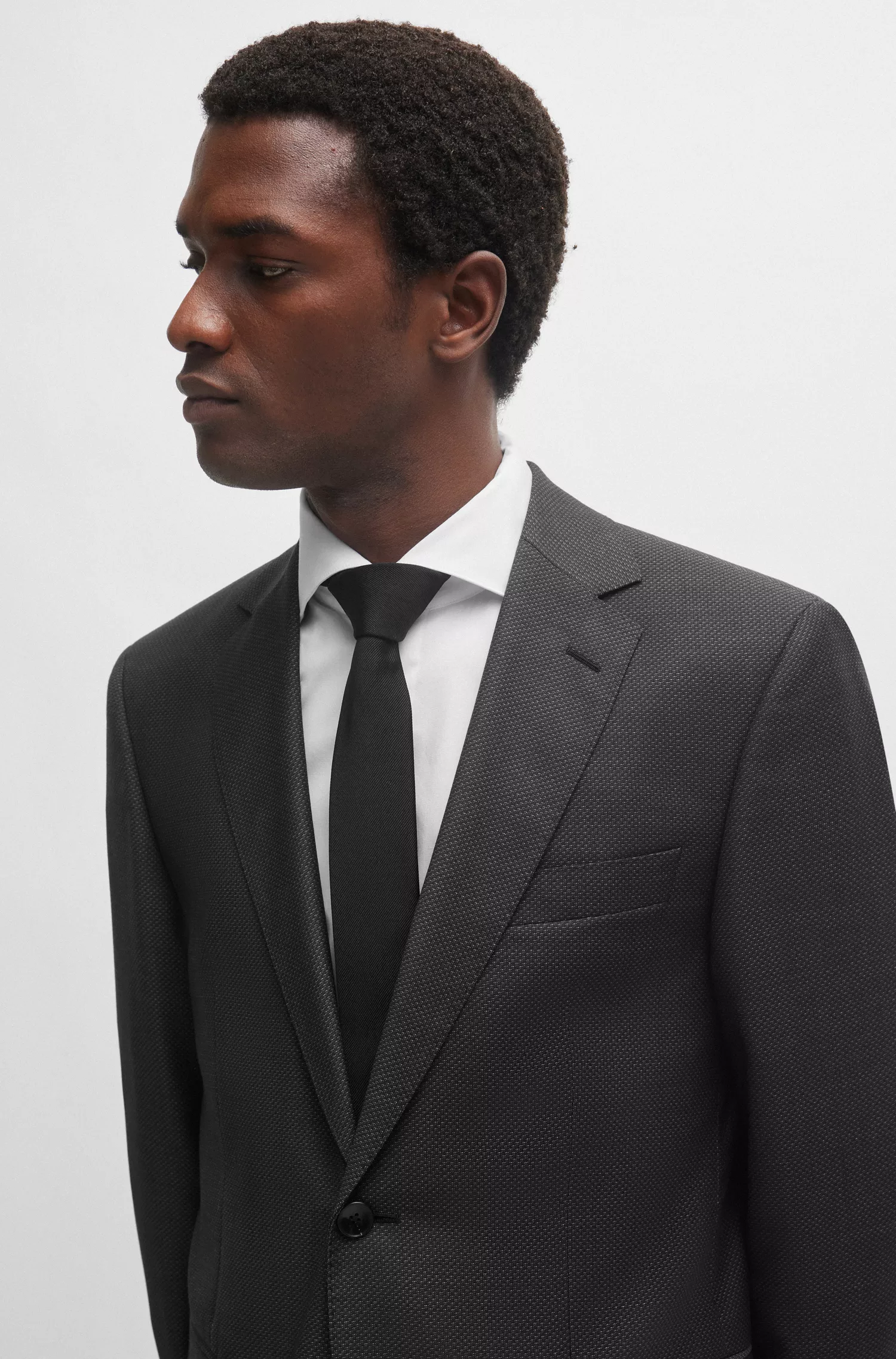 Terno BOSS preto, corte regular, em lã virgem com microestampa.