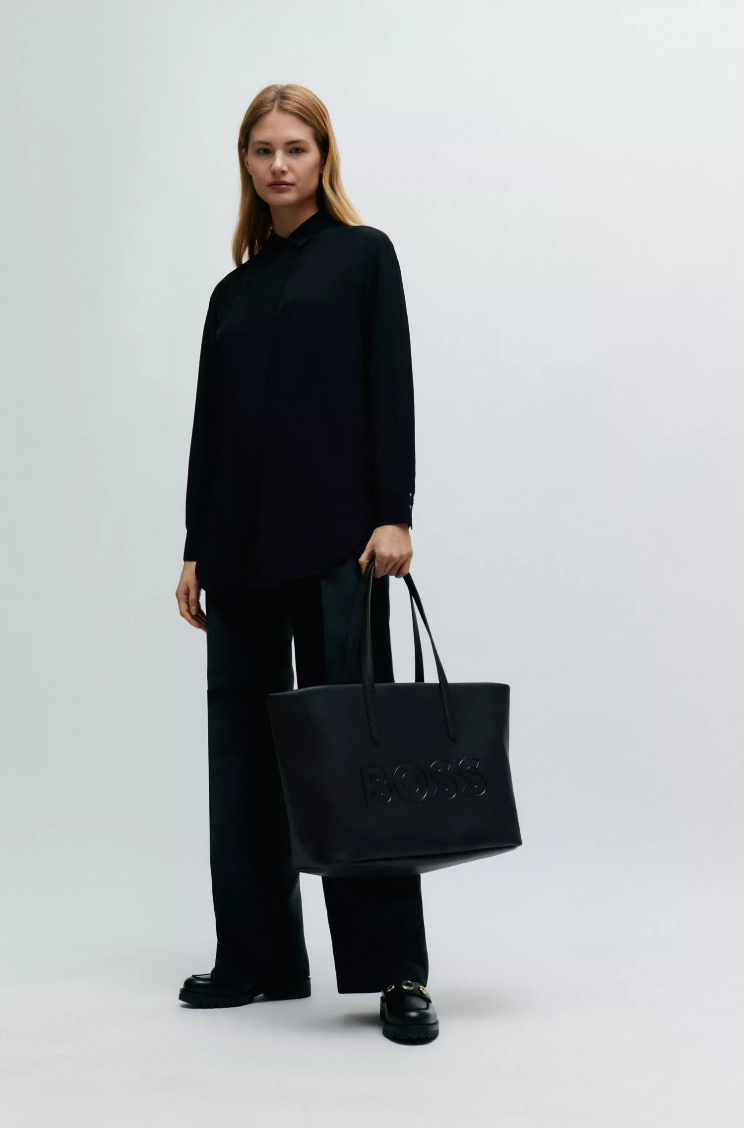 Bolsa de compras BOSS em couro sintético granulado preto com logotipo em contorno.
