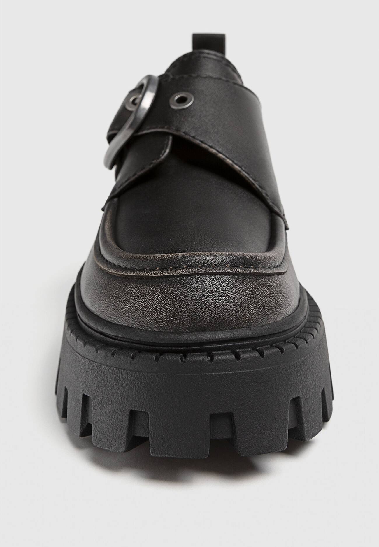 Sapatos baixos com fivela e solado tratorado.