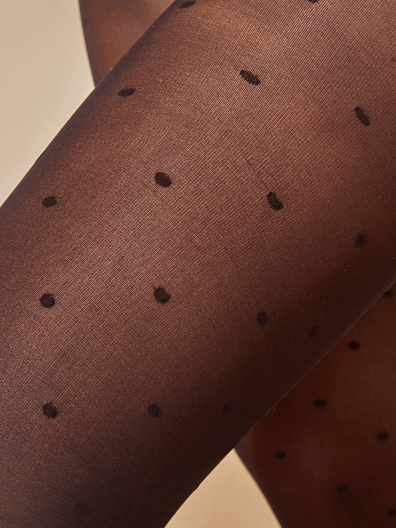 Meias-calças de maternidade com estampas lisas de bolinhas pretas escuras e outros padrões.