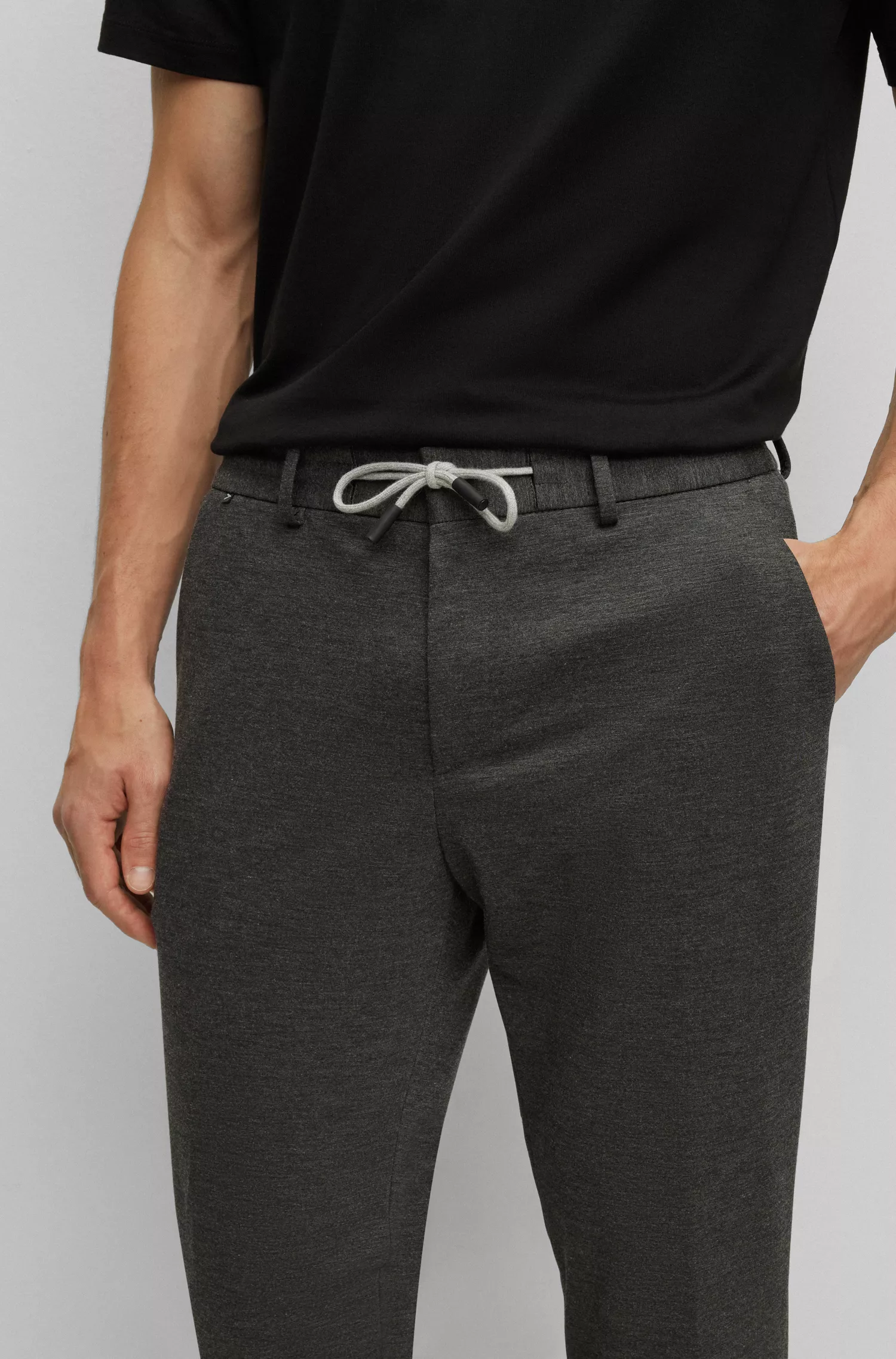 Calça BOSS preta, corte slim, em malha interlock de alta performance com elasticidade.