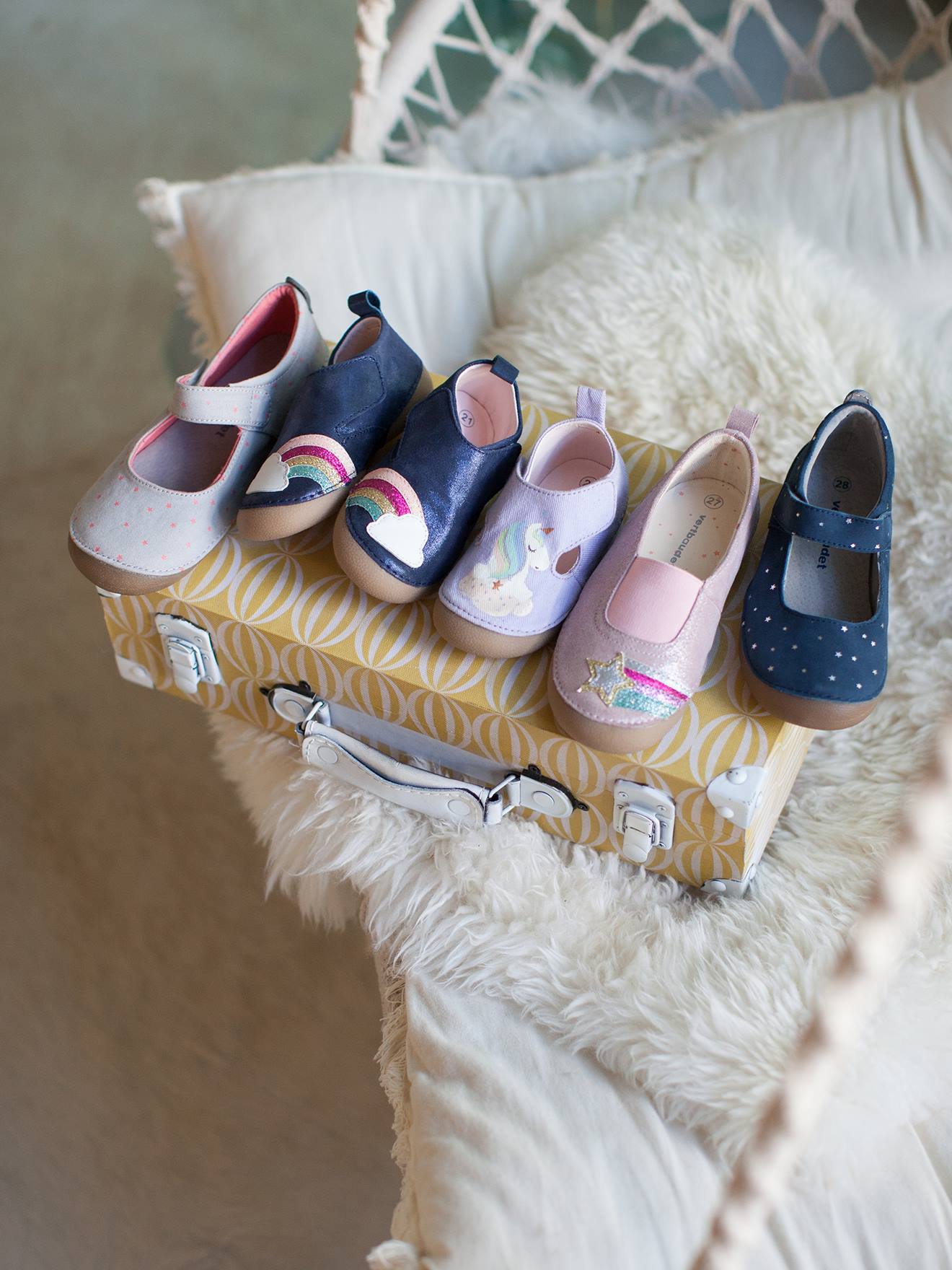 Pantufas de bebê em couro claro, lisas em azul escuro com estampas.