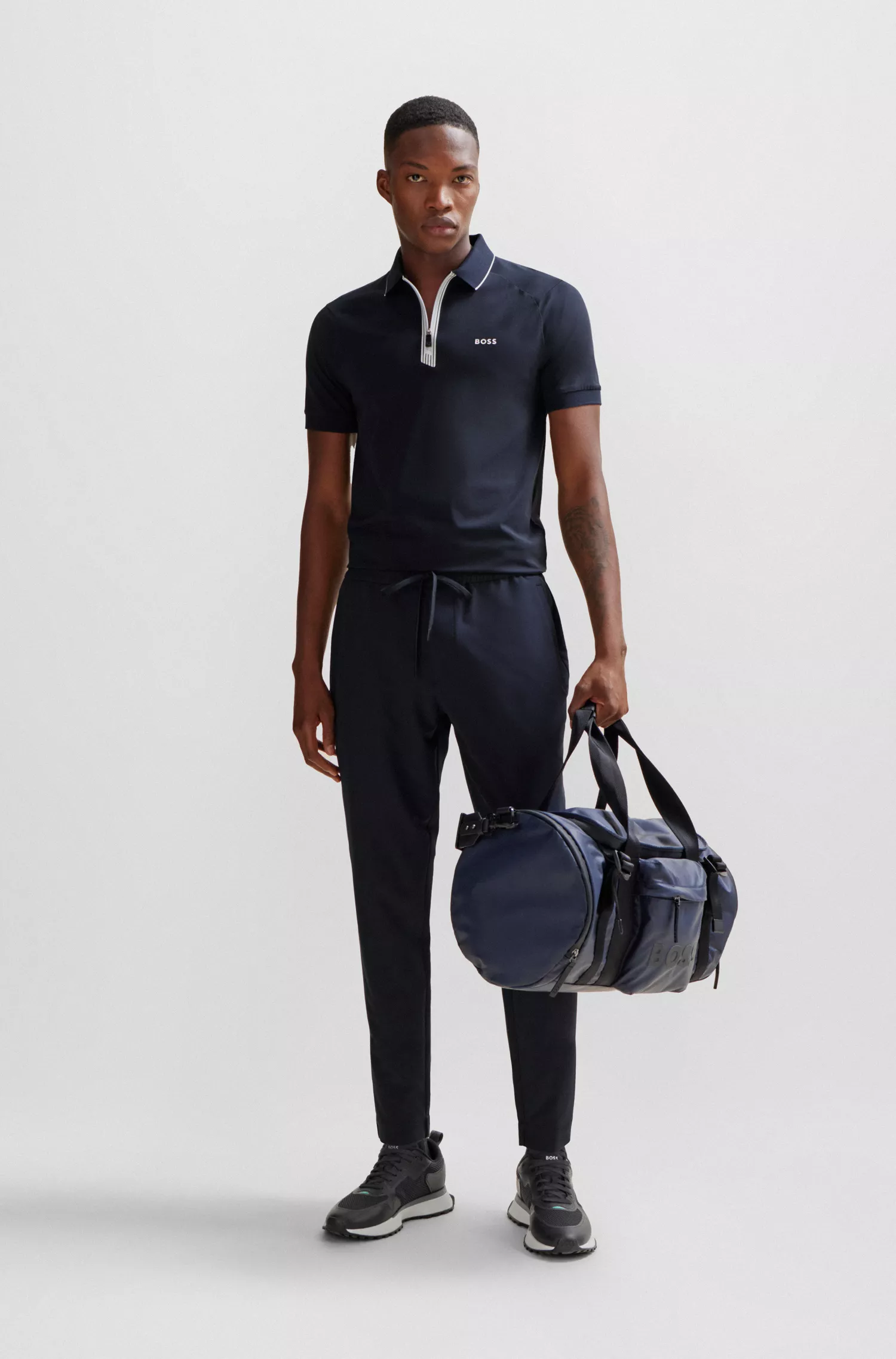 Camisa polo BOSS verde, de algodão stretch, corte slim, com fecho de zíper.