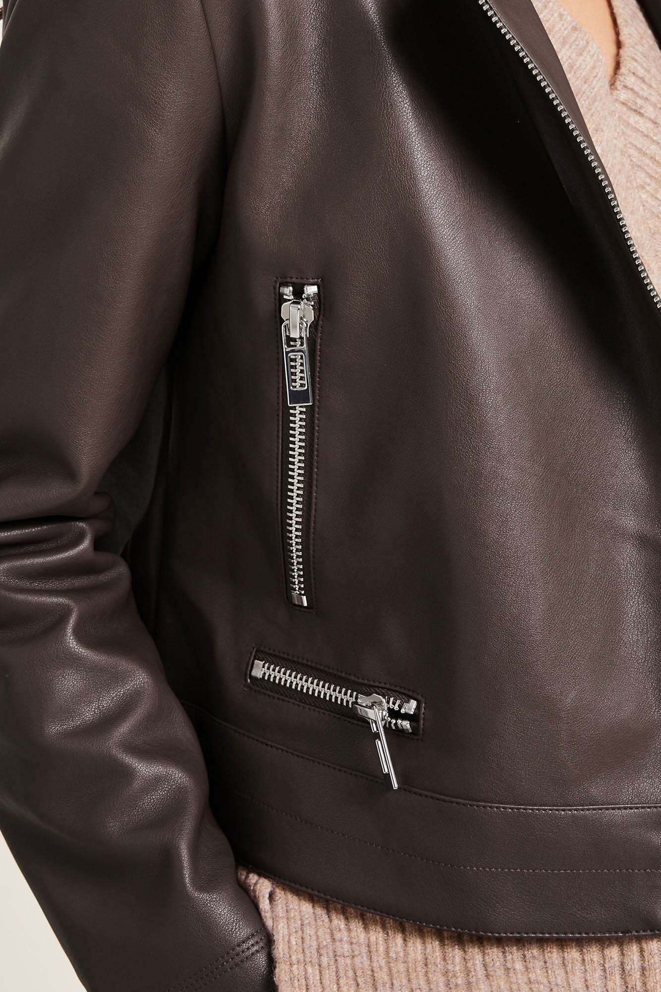 Jaqueta de couro sintético estilo motociclista com zíper.
