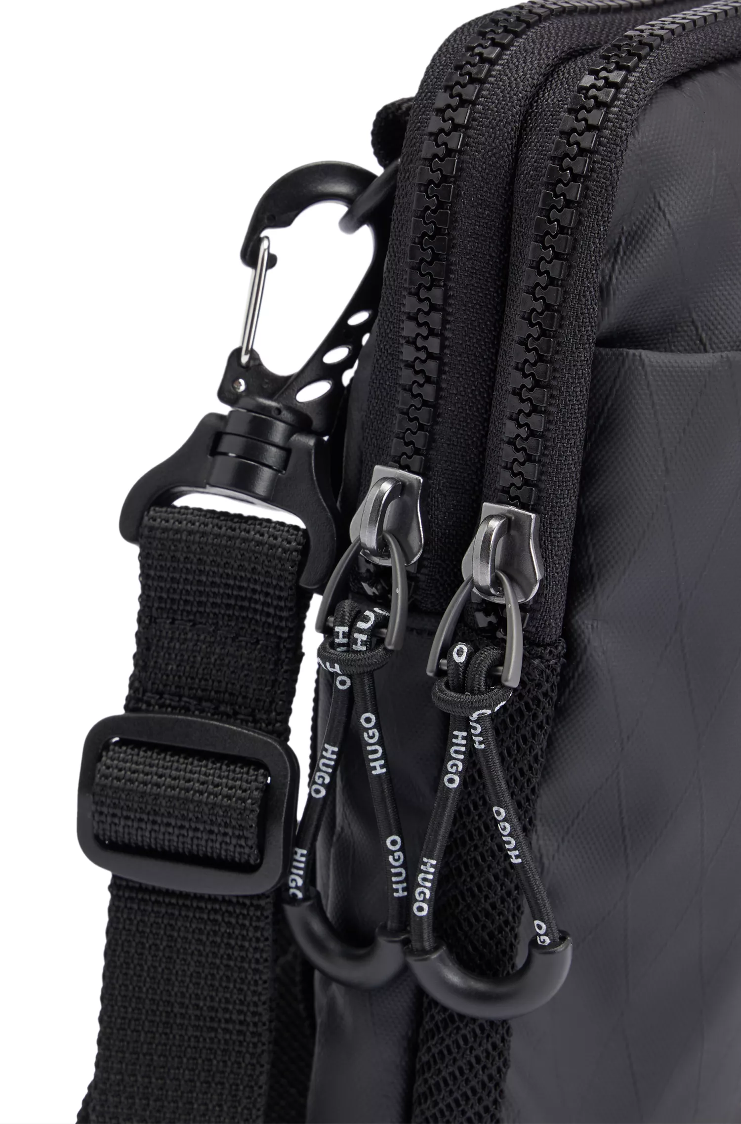 Bolsa estilo repórter HUGO com logo em contorno vermelho, confeccionada em material com textura de diamante.