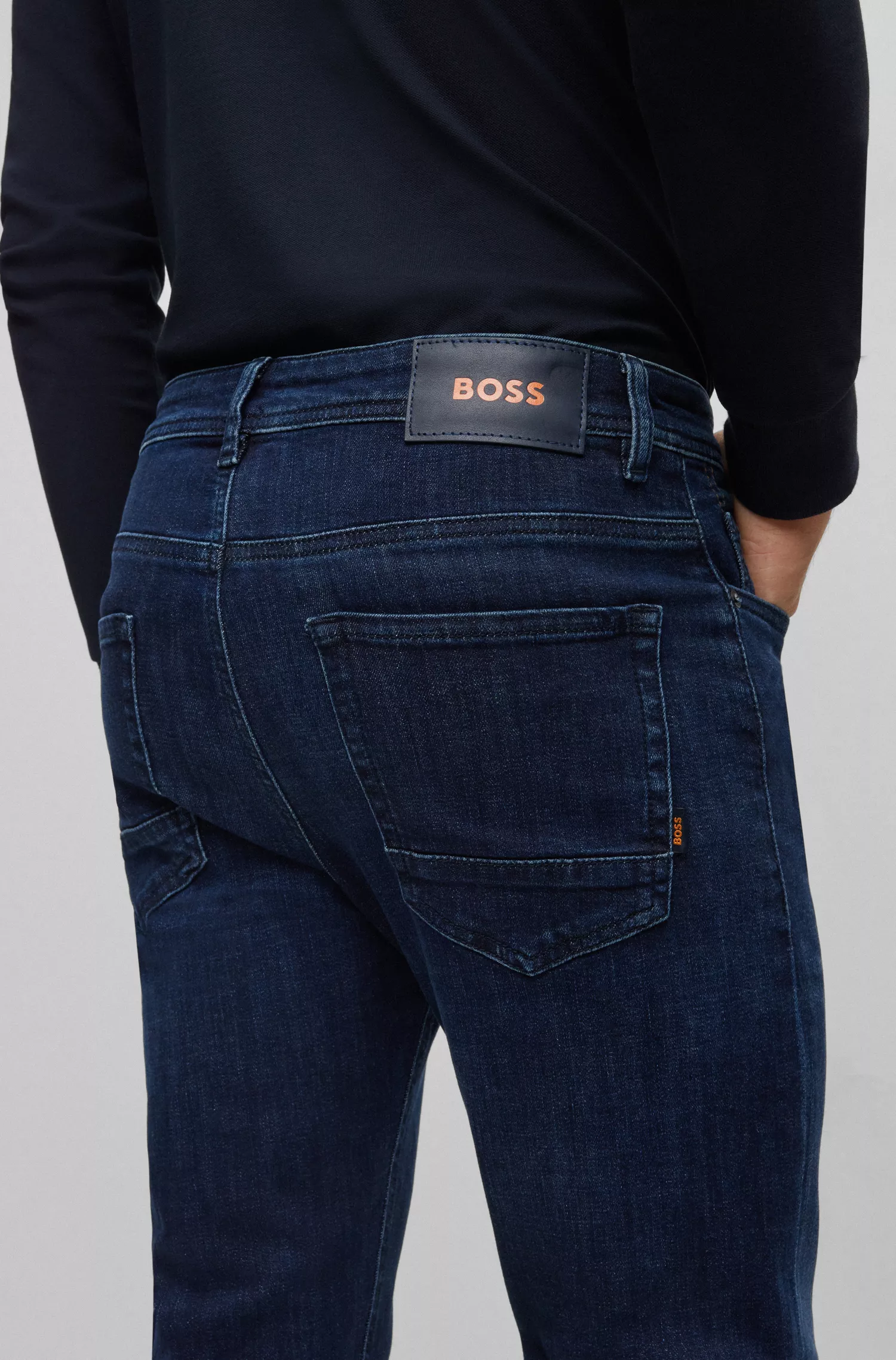 Calça jeans BOSS laranja, corte afunilado, em denim superelástico azul-escuro.