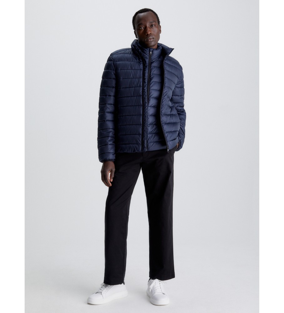 Jaqueta Calvin Klein de plumas, confeccionada com materiais reciclados, na cor azul marinho.