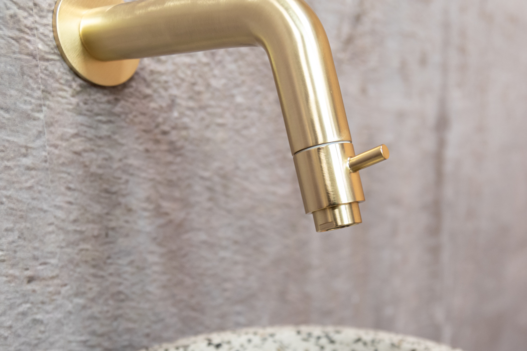 Saniclear Seba fonteinset met bruin eiken plank, zwart-witte terrazzo waskom en gouden kraan voor in het toilet